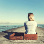 Frau auf Steg blickt Richtung Meer